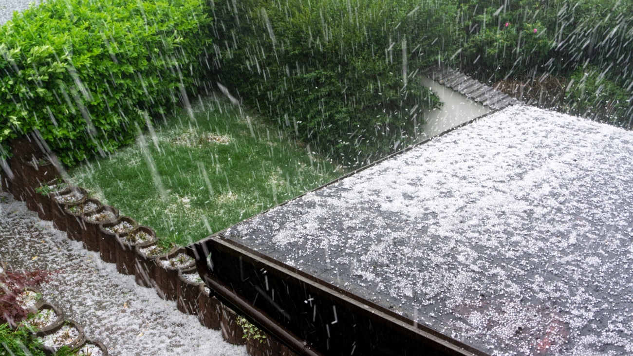 Hail falling on the roof of a residential home during a hailstorm.